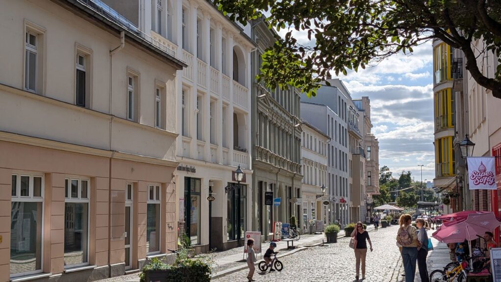Belebte Altstadtgasse mit Kopfsteinpflaster in Köpenick