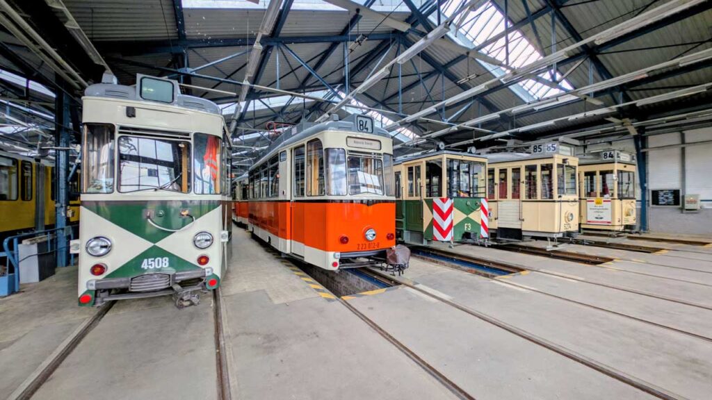 Mehrere historische Berliner Straßenbahnwagen in der Wagenhalle des Depots Wendenschloßstraße.