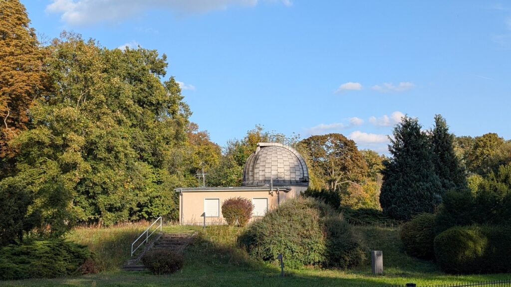 Gebäude und Kuppel der Archenhold-Sternwarte zwischen herbstlichen Bäumen im Treptower Park