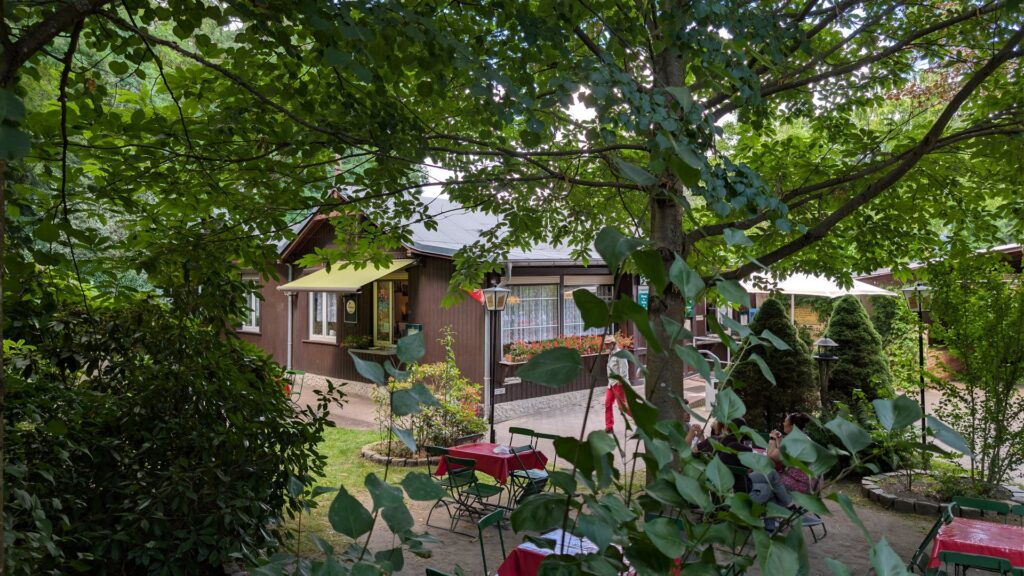 Biergarten der Waldgaststätte Hanffs Ruh unter Bäumen.