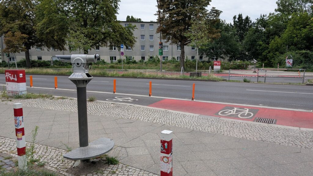 Blickmarke am ehemaligen Grenzübergang Sonnenallee und roter Radspur