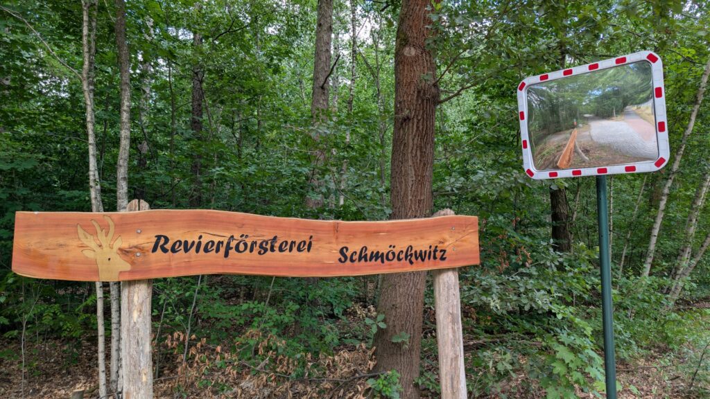 Holzschild der Revierförsterei Schmöckwitz im Wald.