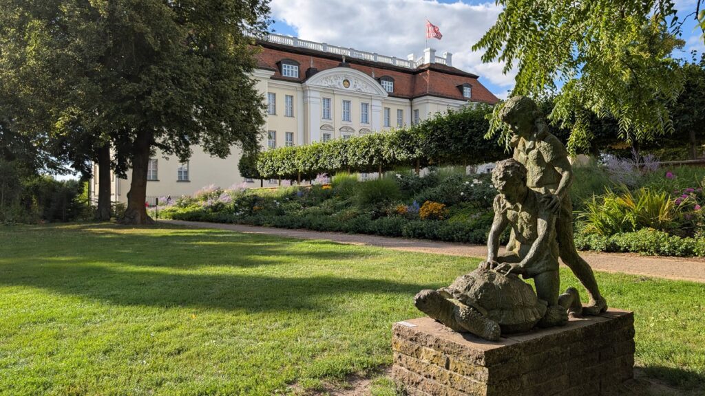 Skulptur im Schlosspark Köpenick mit Schloss im Hintergrund