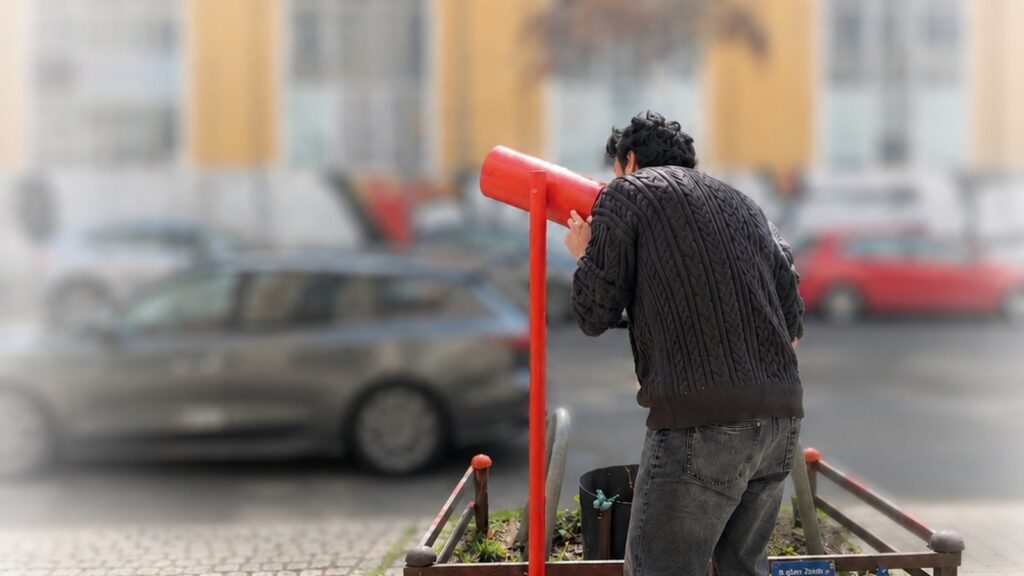 Rotes Sehrohr des Walk of Fame Schöneweide vor Industriearchitektur