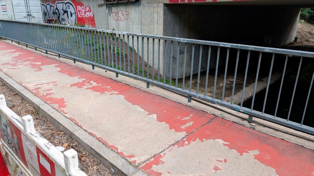 Abgenutzter Radweg auf der Wuhlebrücke Am Bahndamm