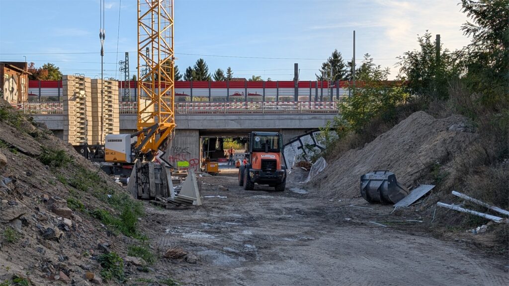 Baustelle der neuen östlichen Personenunterführung am Bahnhof Köpenick mit Baufahrzeugen unter den Gleisen