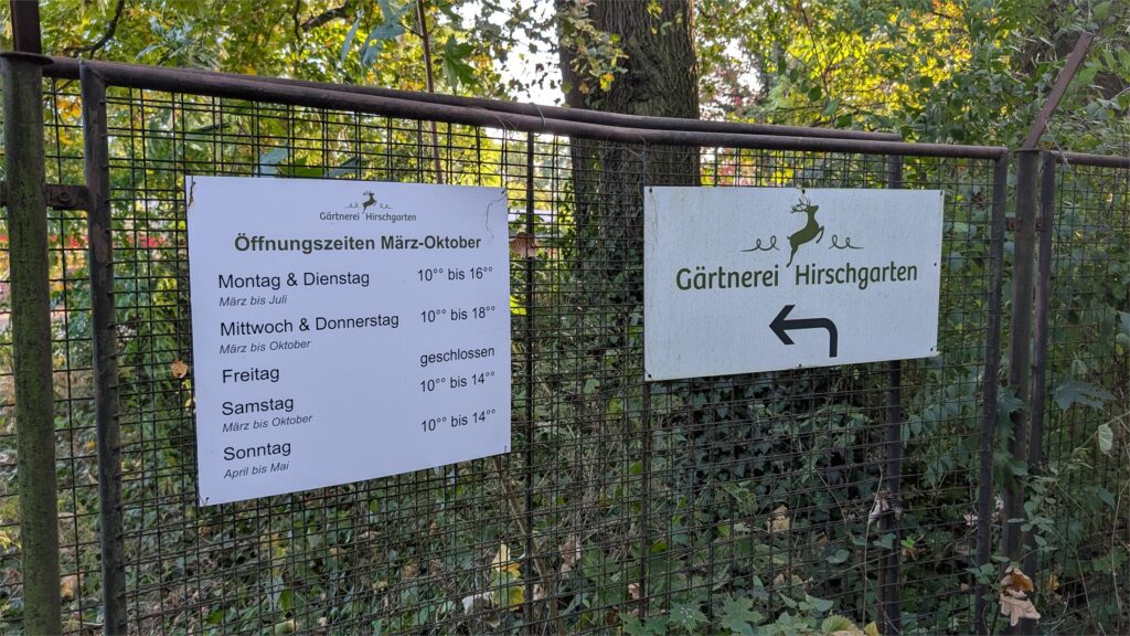 Hinweisschilder und saisonale Öffnungszeiten am Eingang der Gärtnerei Hirschgarten