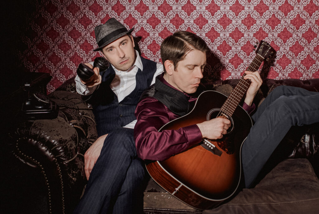 Sebastian Zett am Telefon und Daniel Lindenblatt mit Gitarre