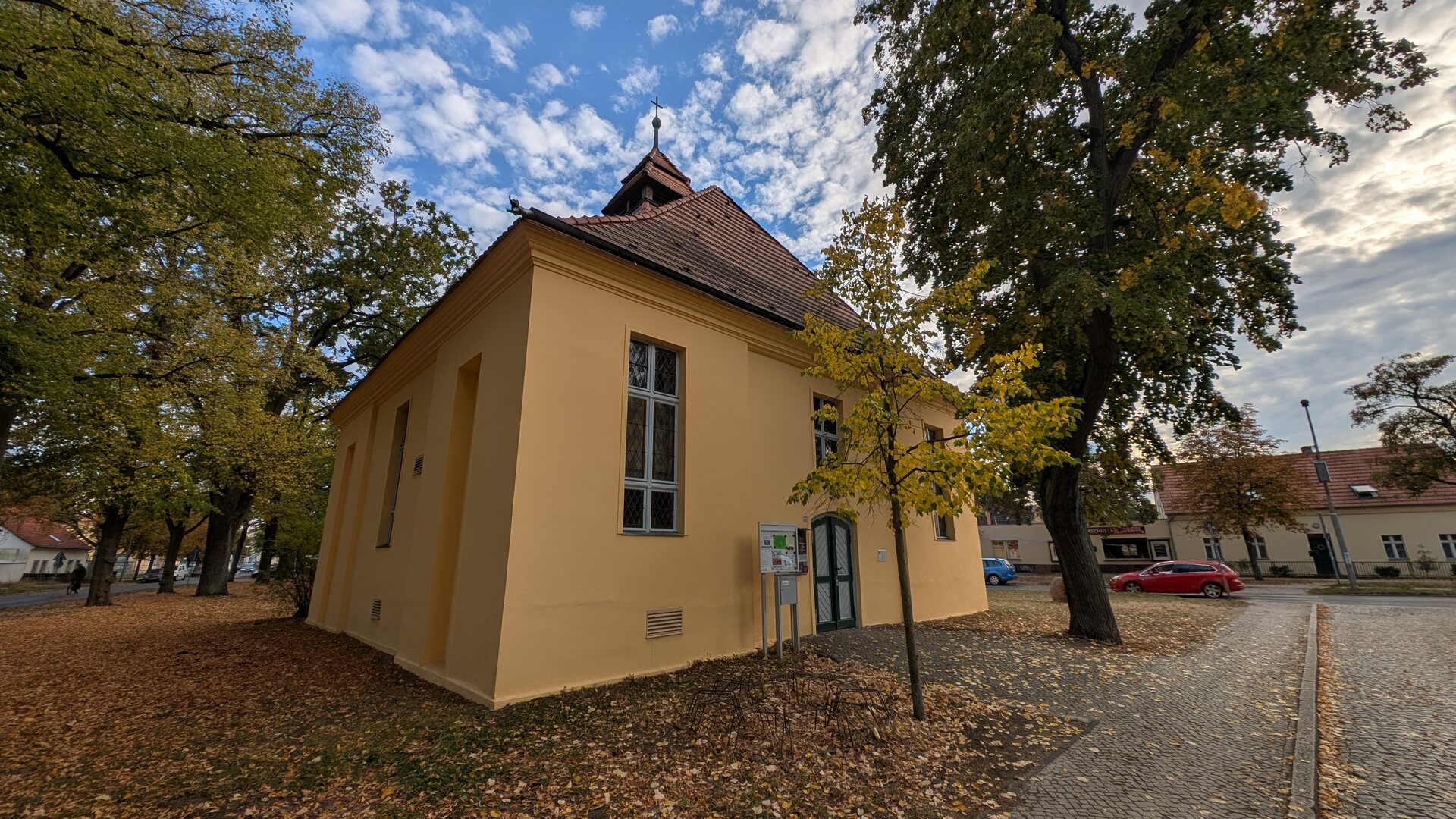 Gelbe Dorfkirche Müggelheim zwischen alten Bäumen
