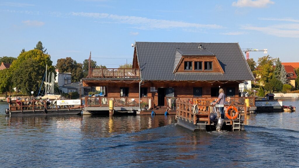Schwimmendes Blockhaus der SpreeArche mit Boot auf der Müggelspree