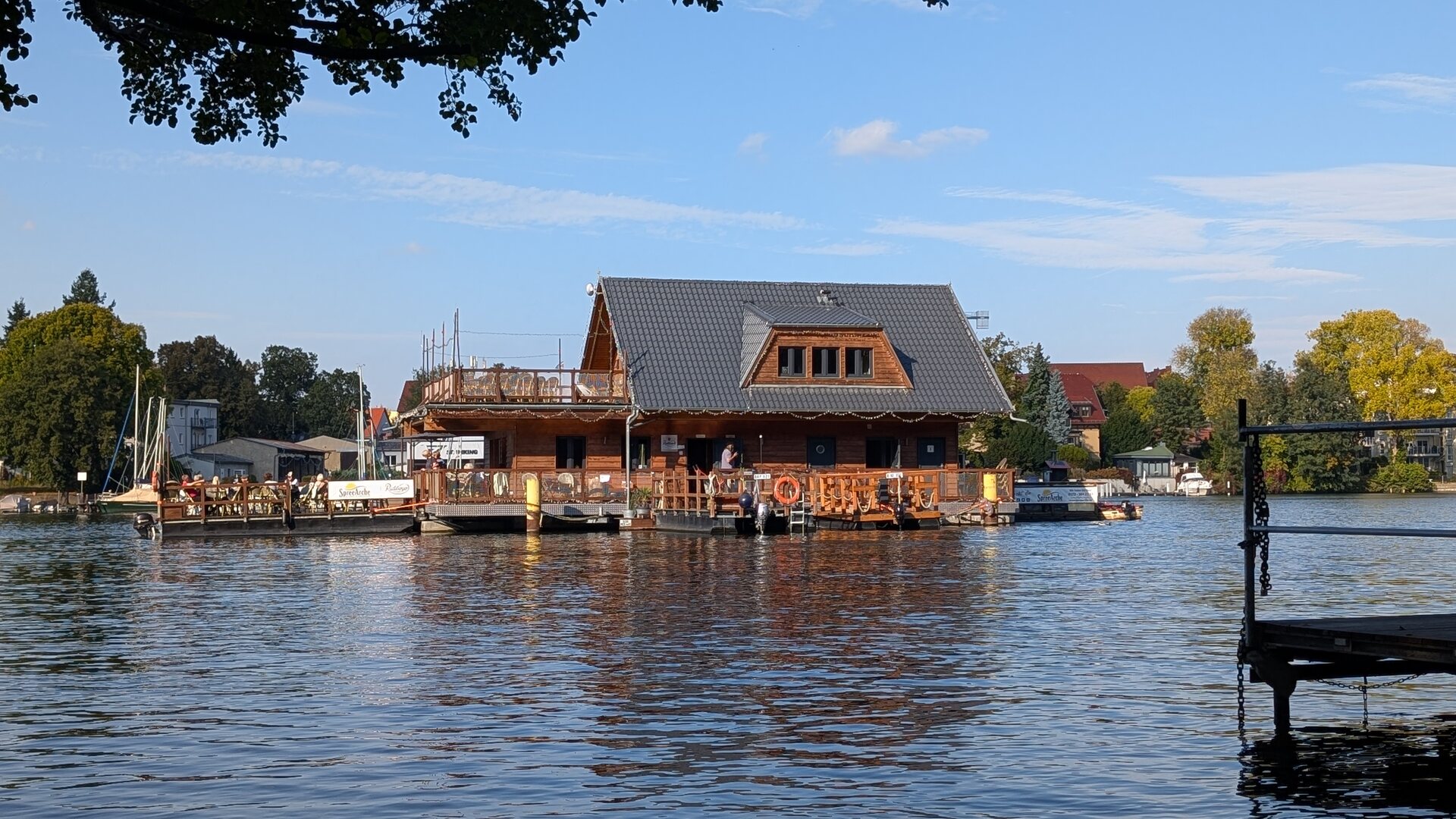 SpreeArche mit Außenterrasse vom bewaldeten Ufer aus gesehen